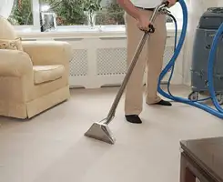 Carpet cleaning professional removing dirt and stains with a hot-water extraction tool in a home, Albuquerque, NM.